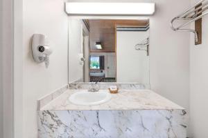 een badkamer met een wastafel en een spiegel bij Post Oak Inn in Brownwood
