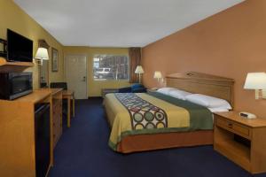 a hotel room with a large bed and a television at Super 8 by Wyndham Breaux Bridge in Breaux Bridge +19 photos