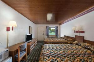 Post Oak Inn في براونوود: غرفة فندقية بسريرين وتلفزيون بشاشة مسطحة