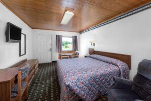 a hotel room with a bed and a tv at Post Oak Inn in Brownwood