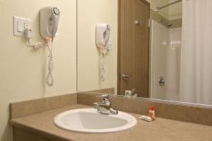 łazienka z umywalką i telefonem na ścianie w obiekcie Super 8 by Wyndham St-Jerome w mieście Saint-Jérôme