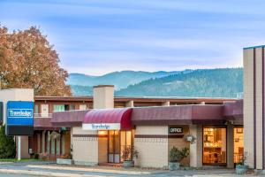 a hotel front of a building with mountains in the background at Travelodge by Wyndham Kalispell in Kalispell