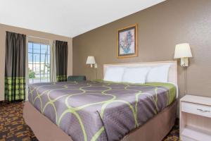 a hotel room with a large bed and a window at Super 8 by Wyndham Antioch/Nashville South East in Antioch