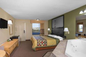 a hotel room with a bed and a bathroom at Super 8 by Wyndham Dunn in Dunn