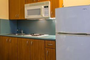 a kitchen with a white refrigerator and a microwave at Travelodge Suites by Wyndham Lake Okeechobee in Okeechobee