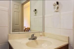 a bathroom with a sink and a mirror at Travelodge Suites by Wyndham Lake Okeechobee in Okeechobee