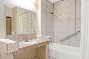 a bathroom with a sink and a tub and a shower at Super 8 by Wyndham St. Louis Airport in Woodson Terrace