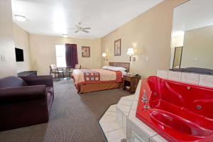 een hotelkamer met een bed en een woonkamer bij Super 8 by Wyndham St. Louis Airport in Woodson Terrace