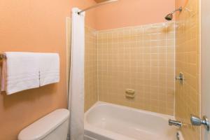 a bathroom with a shower and a tub and a toilet at Super 8 by Wyndham Strongsville/Cleveland in Strongsville