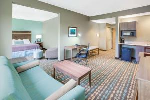 a hotel room with a bed and a living room at Wingate by Wyndham Bossier City in Bossier City