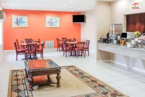 a dining room with tables and chairs in a restaurant at Super 8 by Wyndham Brenham TX in Brenham