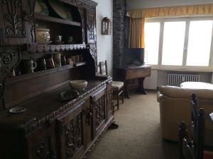 a living room with a large wooden cabinet and a couch at Alloggio a Sestriere fronte piste in Sestriere