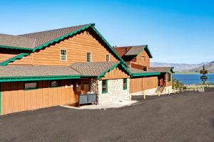 a group of wooden buildings with a lake in the background at Topaz Lodge in Gardnerville