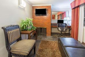 a living room with a chair and a desk with a television at Global Inn in Coos Bay