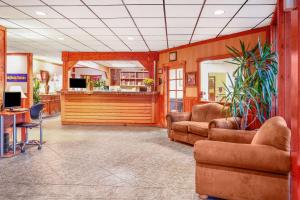 a lobby with two chairs and a reception desk at Howard Johnson by Wyndham Helena in Helena