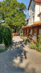 a walkway in front of a building with a tree at Hotel - Gasthof Erber in Sinzing
