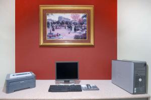 a desk with a computer and a printer and a picture at Super 8 by Wyndham Farmers Branch/North Dallas in Farmers Branch
