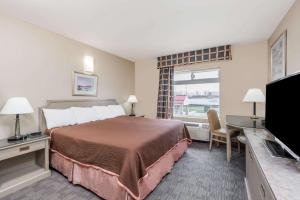 ein Hotelzimmer mit einem Bett und einem TV in der Unterkunft London Travel Inn in London