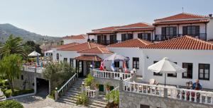 uma vista para um edifício com mesas e guarda-sóis em Dionyssos em Skopelos Town