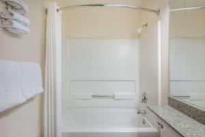 a white bathroom with a tub and a shower at Knights Inn Allentown in Allentown