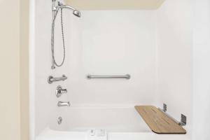 a bathroom with a shower with a wooden board on the sink at Microtel Inn & Suites by Wyndham Franklin in Franklin