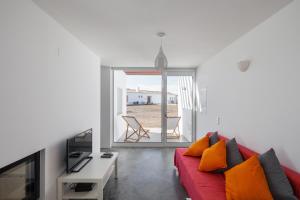 a living room with a red couch and a table at Pe no Monte in São Teotónio