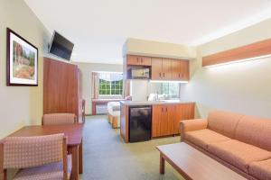 a hotel room with a kitchen and a living room at Microtel Inn and Suites Gassaway in Bison
