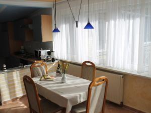 a dining room table with chairs and a white table cloth at Spacious Bungalow near Sea in Grundshagen in Grundshagen