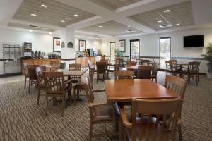 comedor con mesas y sillas de madera en Wingate by Wyndham Augusta Fort Eisenhower, en Augusta