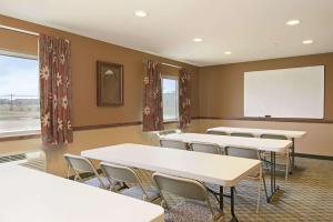 une salle de classe avec des tables et des chaises et un tableau blanc dans l'établissement Super 8 by Wyndham Topeka at Forbes Landing, à Topeka