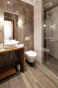 a bathroom with a sink and a toilet and a shower at Hotel Passpartù Home Garni in Belgrade