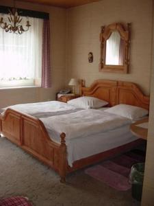 um quarto com uma grande cama de madeira e um espelho em Hotel Schmidt em Selb