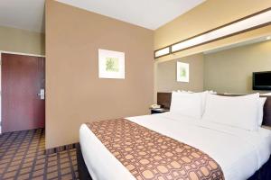 una habitación de hotel con una cama grande en una habitación en Microtel by Wyndham Perry National Fairground Area I-75, en Perry