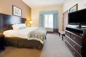 a hotel room with a bed and a flat screen tv at Wingate by Wyndham Erlanger - Florence - Cincinnati South in Erlanger