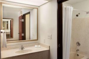 a bathroom with a sink and a mirror at Super 8 by Wyndham Garland Rowlett East Dallas Area in Garland +38 photos