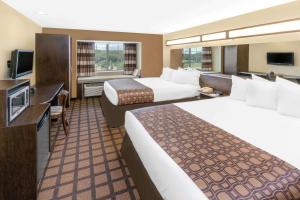 Un pat sau paturi într-o cameră la Microtel Inn & Suites by Wyndham Ozark