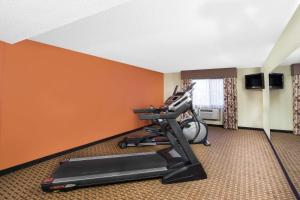 a room with a treadmill and a room with orange walls at Super 8 by Wyndham Clive IA in Clive