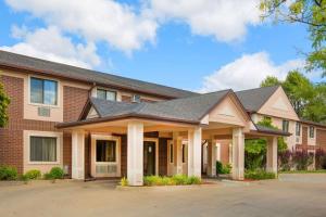 a large brick building with a roof at Super 8 by Wyndham Clive IA in Clive