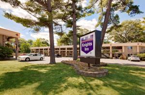 a sign in the grass in front of a building at Knights Inn Traverse City in Traverse City