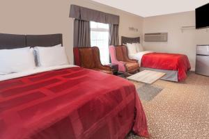 um quarto de hotel com duas camas e duas cadeiras em Knights Inn Kingston em Kingston