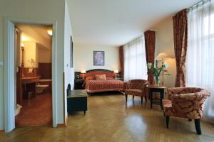 プラハにあるエリゼ ホテルのベッド、テーブル、椅子が備わるホテルルームです。