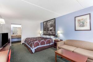 a hotel room with a bed and a couch at Super 8 by Wyndham Kingston in Kingston