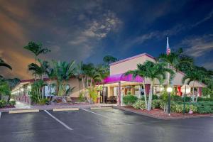 a building with palm trees in front of a parking lot at Knights Inn Port Charlotte in Port Charlotte