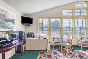 a living room with a table and chairs and windows at Knights Inn Hadley in Hadley