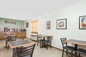a dining room with tables and chairs and a kitchen at Knights Inn - Slaton in Slaton