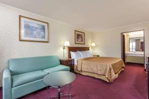 a hotel room with a bed and a couch at Travelodge by Wyndham Seymour in Seymour
