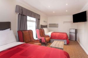 a hotel room with two beds and a tv at Knights Inn Kingston in Kingston