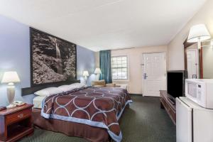 a hotel room with a bed and a tv at Super 8 by Wyndham Kingston in Kingston