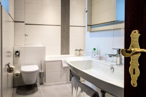 
a bathroom with a toilet, sink, and bathtub at Hotel Imperial in Cologne
