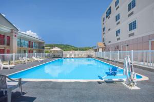 una gran piscina con sillas y un edificio en Microtel Inn & Suites by Wyndham Harrisonburg, en Harrisonburg